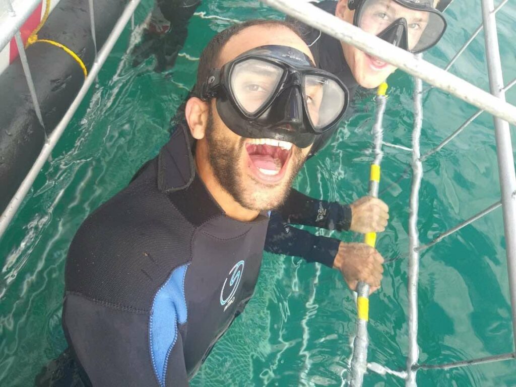 Why it is great diving with sharks in winter 1 diver with mask on in shark cage smiling